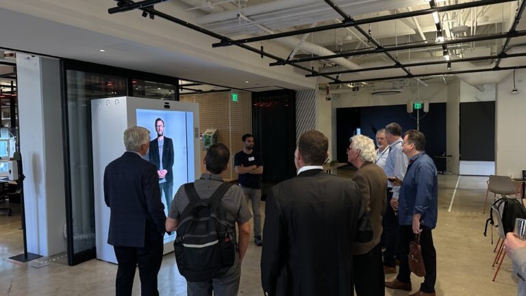 Attendees watch a life-size digital display demonstration.
