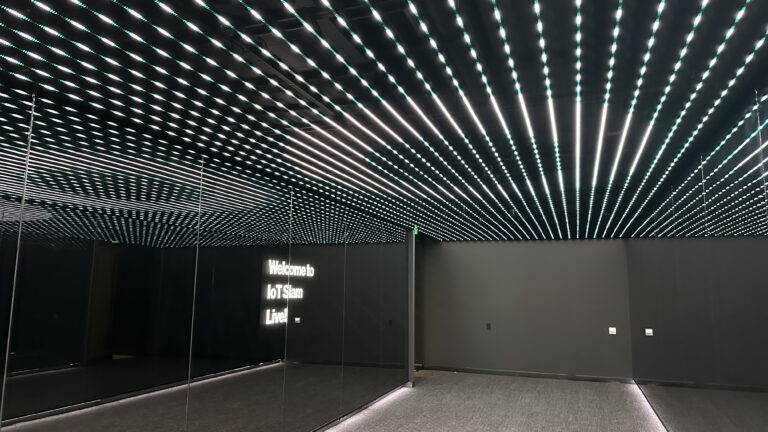 Illuminated ceiling and IoT Slam Live welcome sign at the venue.